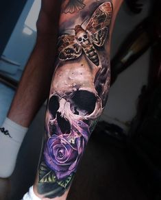 a person with a tattoo on their arm has a skull and flowers in front of them