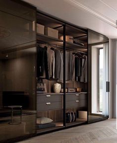 a walk - in closet with mirrored doors and clothes hanging on the shelves, along with an open window