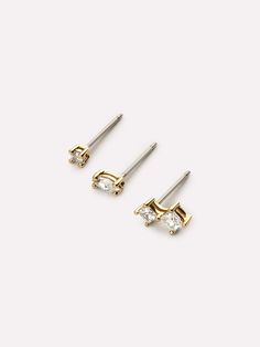 This stud earrings set with white cubic zirconia set in prongs is sure to add a bit of sparkle to your earring game. Dipped in 14K gold, these earrings are delightfully comfortable and so lightweight, you'll forget you have them on. Mix or match these sparkling studs earrings set for an original look or create the ultimate ear stack. This set is also available with pink-red gemstones, and with blue-green gemstones. • Versatile studs dipped in 14K gold��• Three earrings with prongs-set white cubic Three Earrings, Earring Sets, Ear Stack, Red Gemstones, Cubic Zirconia Earrings, Studs Earrings, Green Gemstones, Stud Earrings Set, Letter Necklace