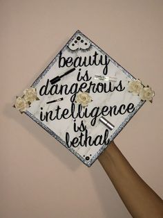 a graduation cap that says beauty is dangerous, inteliligence is verhal