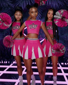 three girls in pink cheerleader outfits standing next to each other