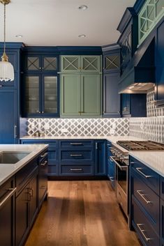 a kitchen with blue cabinets and white counter tops