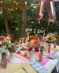 the table is set with flowers and candles for an outdoor dinner or party in the backyard