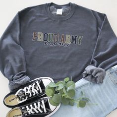 Show your unwavering support with our "Proud Army Mom" sweatshirt! This shirt proudly features the message in a combination of collegiate and script fonts, set against a color palette inspired by the Army, and boldly outlined in soft white. Product Details Ideal for any situation, a unisex heavy blend crewneck sweatshirt is pure comfort. These garments are made from polyester and cotton. This combination helps designs come out looking fresh and beautiful. The collar is ribbed knit, so it retains its shape even after washing. There are no itchy side seams on these sweaters. >50% cotton, 50% polyester >Medium-heavy fabric (8.0 oz/yd² (271.25 g/m²)) >Loose fit >Sewn-in label >Runs true to size Care Instructions Machine wash: cold (max 30C or 90F); Non-chlorine: bleach as needed; Tumble dry: l Cotton Sweatshirt With Lettering For Campus, Cotton Team Spirit Sweatshirt With Lettering, Collegiate Cotton Sweatshirt With Lettering, Cotton Fan Apparel Sweatshirt With Text Print, School Spirit Cotton Sweatshirt With Lettering, Cotton College Sweats With Letter Print, Collegiate Cotton Sweats With Letter Print, Relaxed Fit Text Print Sweatshirt For School Spirit, Relaxed Fit Sweatshirt With Text Print For School Spirit