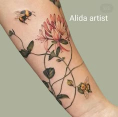 a woman's arm with flowers and a bee on the back of her arm