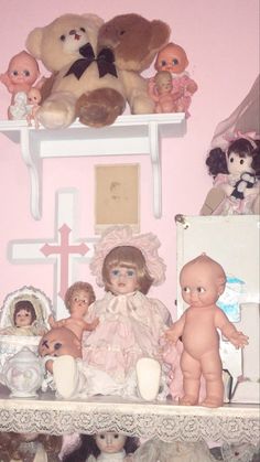 there are many dolls and teddy bears on the shelf