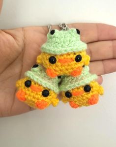 small crocheted keychain with two yellow and green ducks on it's sides