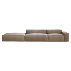 a large sectional couch sitting on top of a white floor next to a wooden table