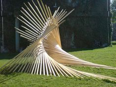 a sculpture made out of sticks in the grass