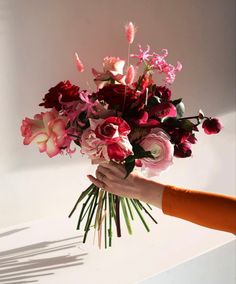 a person holding a bouquet of flowers in their hand