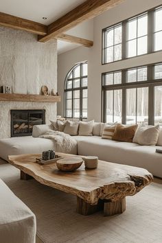 a living room filled with furniture and a fire place in front of a large window