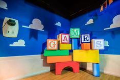 colorful blocks are stacked on top of each other in front of a blue wall with clouds