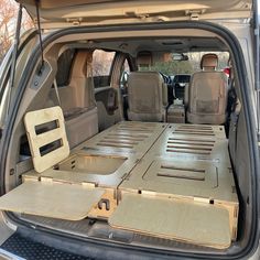 the back end of a van with its cargo compartment open and two seats folded down