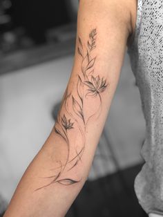 a woman's arm with a flower tattoo on the left side of her arm