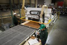 two workers in a factory working on machinery