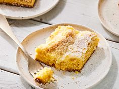 a piece of cake on a plate with a fork next to it and another slice in the background