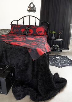 a bedroom with a bed covered in black fur and red skulls on the coverlet