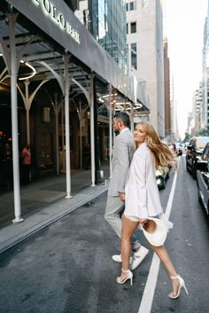 a man and woman are walking down the street