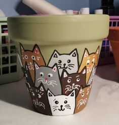 a flower pot with cats painted on it