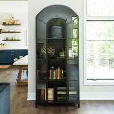 a black book case with books on it in the middle of a room