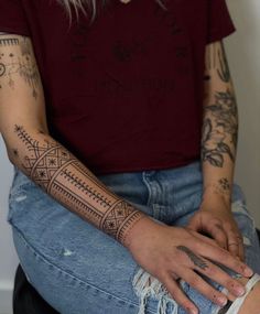 a woman with tattoos on her arm sitting down