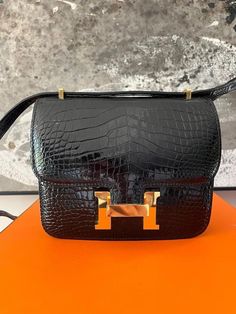 Pre-Owned Hermes Croc Skin Constance. Beautiful Croc skin, well kept condition. Perfect for every day use. In a classic color, has interior slit pocket and one exterior outside slit pocket. The perfect bag for any Hermes lover. Where it day or night.  Color - Black  Size - 19  Material - 100% Porosus Crocodile Skin, Interior Togo Leather  Made in - France  Condition  - Pre-owned Excellent, Has been sent to Leather SPA. Looks like new. Some slight hairline scratches on hardware. No rips or tears. See pics and video. A must have. It Day, Togo Leather, Sling Bags, Crocodile Skin, Perfect Bag, Cross Body Handbags, Purses And Handbags, Bathing Beauties, Spa