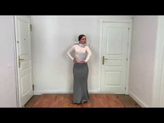 a woman is standing in an empty room with her hands on her hips and looking at the camera