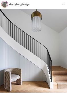 a white staircase with a chandelier hanging from the ceiling next to a wooden floor