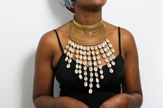 African Brass necklace with cowries, Brass Choker Necklace, Statement Necklace, Cowrie Shell Jewelry, One size fit all, Christmas Gift  The necklace is handmade using brass metal and decorative cowrie shells. The necklace is adjustable hence can fit any neck size. Shipping fee is for the first item only, additional items ship for FREE. DHL Express shipping with 3-5 days delivery. To view our brass collection, click here: https://www.etsy.com/shop/NkoroiCrafts?ref=simple-shop-header-name&listing_id=1295061994&section_id=39639351 *Care instructions* Brass tarnishes with exposure to moisture and oxidation. To clean it, kindly use a lemon wedge. Squeeze the juice and polish along the surface with a clean cloth. Handmade Gold Shell Necklace For Festivals, Gold Beaded Cowrie Shell Jewelry, Traditional Gold Necklace For Beach, Bohemian Gold Cowrie Shell Necklace, Sun Medallion, African Beaded Bracelets, Cowrie Shell Jewelry, Sunburst Necklace, Sun Necklace