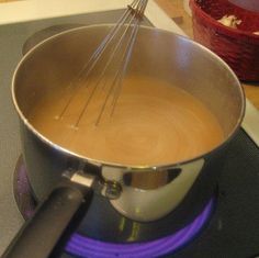 a pot with some whisk in it on the stove