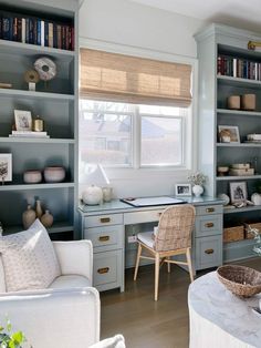 a living room filled with lots of furniture and bookshelves next to a window