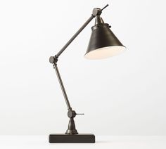 a black desk lamp sitting on top of a white table