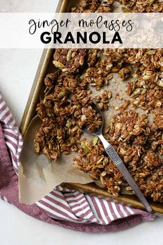 a pan filled with granola on top of a table next to a napkin and spoon