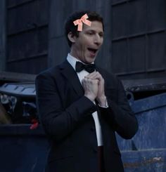 a man in a tuxedo and bow tie making a funny face