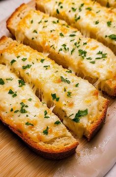 slices of garlic bread on a cutting board with parsley sprinkled on top