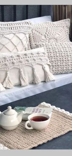 a tray with some tea on top of it next to a pillow and cup filled with liquid