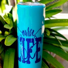 a blue tumbler sitting next to a plant with the words where life is written on it