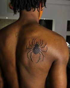 a man with a spider tattoo on his back