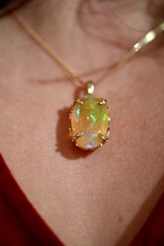 Boasting a dazzling, natural Ethiopian Welo Opal, this pendant is equipped with vivid colorations. Its spectrum of pigments range from a vibrant green with blue accents in a sea of sunny yellow with deep vivid reds. All facets have been expertly cut, allowing each angle to present a unique color. Faceted Ethiopian Welo Opal Opal size: 25 x 14.8 mm weight: 12.25 CTS 14K Yellow Gold ***PENDANT ONLY *** Chain Included (Italian Made) 1.6 mm 14K Yellow Gold Herringbone Chain - 18” length. Lobster Cla Yellow Gold Oval Fusion Jewelry, Fusion Style Oval Yellow Gold Jewelry, Yellow Gold Opal Oval Pendant Jewelry, Luxury Green Opal Jewelry, Fine Jewelry Ethiopian Opal Pendant, Elegant Untreated Oval Pendant Jewelry, Ethiopian Opal Pendant In Fine Jewelry Style, Unique Untreated Yellow Gold Jewelry, Elegant Untreated Pendant Jewelry