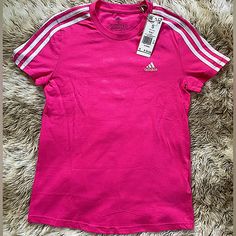 a pink adidas shirt with white stripes on it