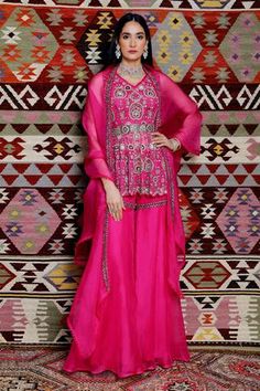 Fuchsia peplum with embroidered details. Paired with sharara and an embroidered organza dupatta.
Component: 3
Pattern: Embroidered
Neckline: V-neck
Sleeve Type: Sleeveless
Fabric: Organza, Tulle
Color: Pink
Other Details: 
Scalloped peplum
Loop hem neckline and dupatta hem
Note: The belt worn by the model is not for sale
Occasion: Destination Wedding - Aza Fashions Peplum Sharara, Ridhima Bhasin, Party Wear Indian Dresses, Sharara Set, Organza Dupatta, Magenta Pink, Embroidered Neckline, Designer Gowns, Set For Women