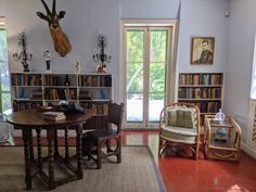 a living room filled with furniture and bookshelves covered in deer heads on the wall