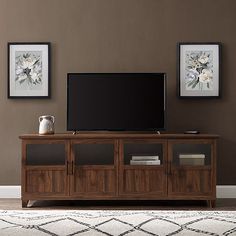 a flat screen tv sitting on top of a wooden entertainment center in a living room