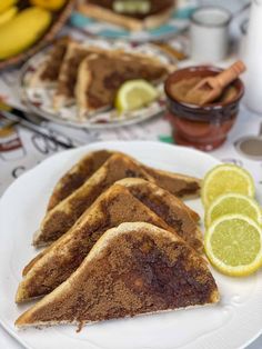 slices of french toast on a plate with lemons and cinnamon in the back ground