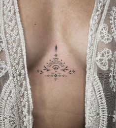 a woman's chest with an arrow tattoo on her left side ribcage