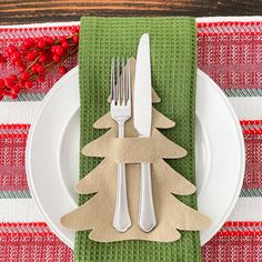 a white plate topped with two forks and a christmas tree cutout on top of it