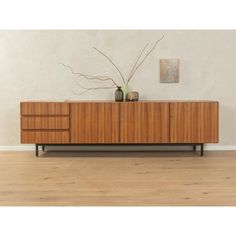 a sideboard with two vases on top of it in a living room setting