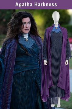 a woman wearing a purple dress and black cape with long sleeves, standing next to a mannequin