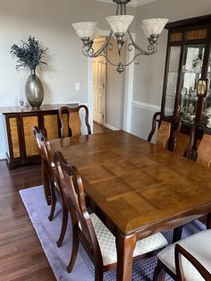 a dinning room table with chairs and a china cabinet in the backround