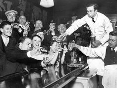 an old black and white photo of people at a bar